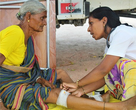 l'infirmière soigne une plaie à la jambe d'une femme